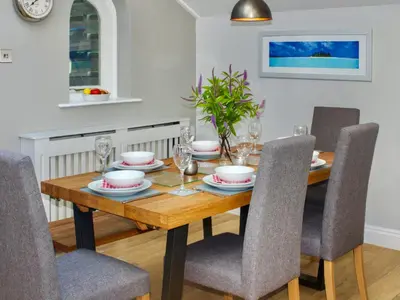 a dining room with a wooden table and chairs at St Monicas in Fowey