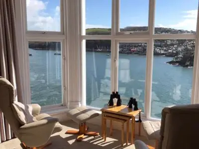 a living room with a large window view of the water at St Catherines Court No 7 in Fowey