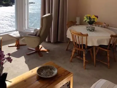a living room with a table and a chair at St Catherines Court No 7 in Fowey
