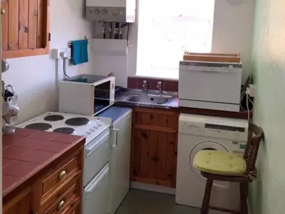 a kitchen with a stove and a washing machine at St Catherines Court No 7 in Fowey