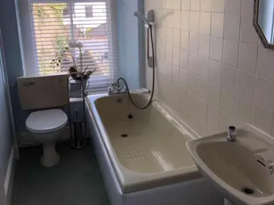 a bathroom with a toilet and a tub and a sink at St Catherines Court No 7 in Fowey