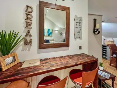 a bar with chairs and a mirror on the wall at Rosie Cottage in Fowey