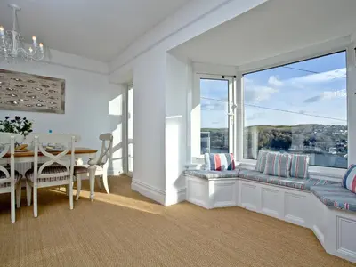 a dining room with a table and a large window at Anchor Loft in Fowey