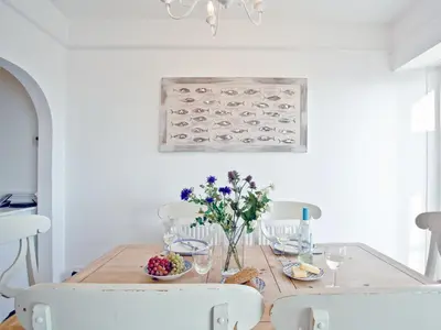a dining room table with flowers and wine glasses at Anchor Loft in Fowey