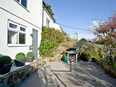 a house with a sidewalk next to a building at Anchor Loft in Fowey