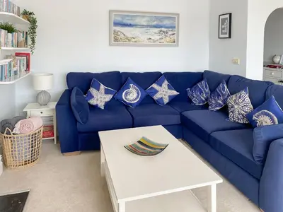 a blue couch with patriotic pillows in a living room at Anchor Loft in Fowey