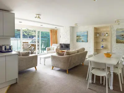 a kitchen and living room with a table and chairs at Middle Deck in Fowey