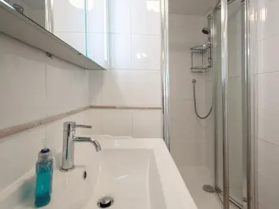 a white bathroom with a sink and a shower at Middle Deck in Fowey