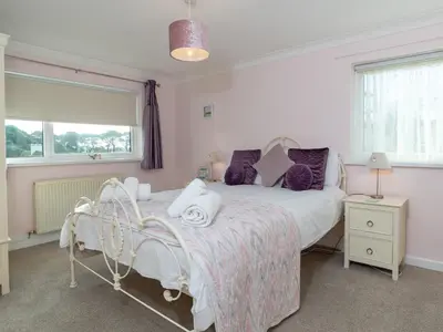 a bedroom with a large bed and a window at Bosula in Fowey
