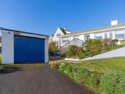 a garage with a blue door in front of a house at Bosula in Fowey