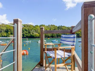 two chairs sitting on a deck overlooking the water at Tarquins in Fowey