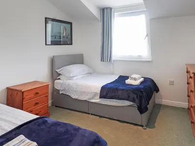 a small bedroom with a bed and a window at Tarquins in Fowey