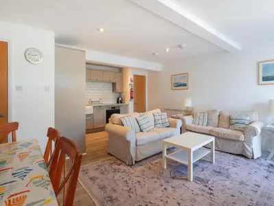 a living room with two couches and a table at Tarquins in Fowey