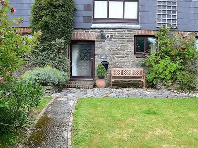 a bench sitting in front of a house at Mill Cottage in Fowey
