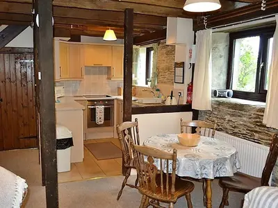 a kitchen and dining room with a table and chairs at Mill Cottage in Fowey