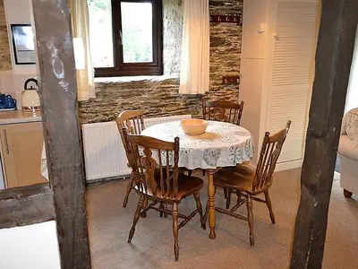 a dining room with a table and chairs in a kitchen at Mill Cottage in Fowey