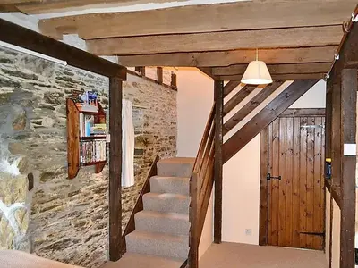 a staircase in a room with a stone wall at Mill Cottage in Fowey