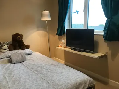 a bedroom with two teddy bears sitting on a bed at Beach Road- short walk to Charlestown, Carlyon Bay & coastal paths- dog friendly in Carlyon Bay