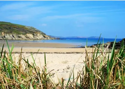 a sandy beach with the ocean in the background at Waves at The Beach House in Falmouth