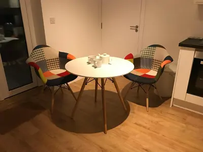 a white table with four chairs in a kitchen at Waves at The Beach House in Falmouth
