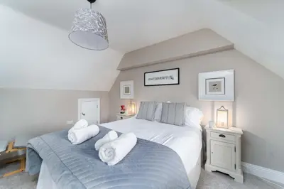 a bedroom with two beds with towels on them at Merlins in Hayle