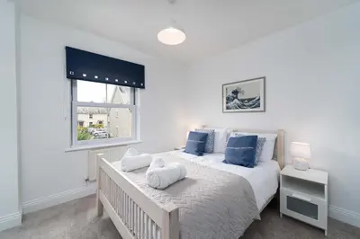 a bedroom with a large bed and a window at Merlins in Hayle