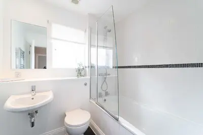 a white bathroom with a sink and a shower at Merlins in Hayle