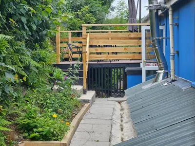 a walkway with a blue building and a wooden gate at Trengilly Wartha Inn in Constantine
