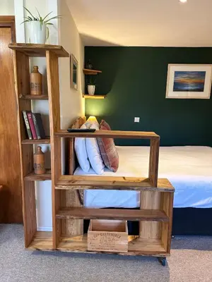 a bedroom with a bed and a wooden book shelf at Trengilly Wartha Inn in Constantine
