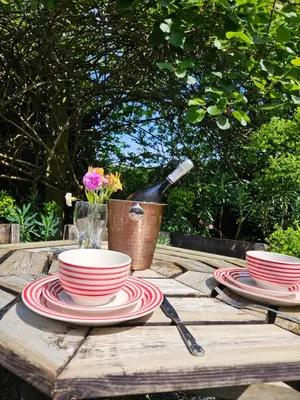 a wooden table with plates and a bottle of wine at Trengilly Wartha Inn in Constantine