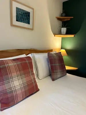 a bed with two plaid pillows on top of it at Trengilly Wartha Inn in Constantine