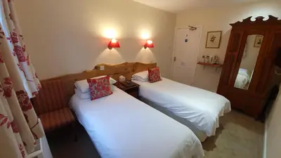 a room with two beds and a mirror at Trengilly Wartha Inn in Constantine