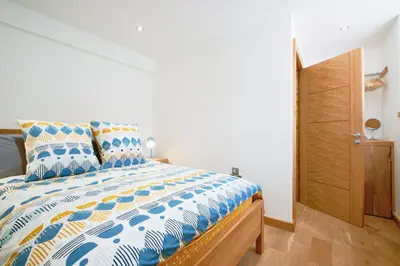 a bedroom with a bed with a blue and white comforter at Finest Retreats - Luxury Holiday Let in Porthleven, Sleeping 2 in Porthleven