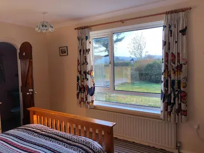 a bedroom with a bed and a large window at Travellers Rest in Launceston
