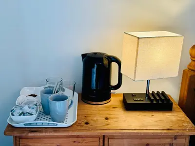 a table with a coffee maker and a lamp on it at Travellers Rest in Launceston