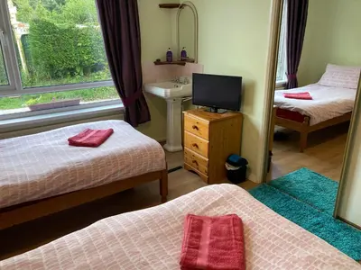 a room with two beds and a television and a sink at Travellers Rest in Launceston