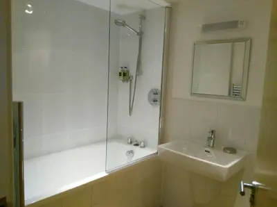 a bathroom with a shower and a sink and a tub at South Fistral Seaview 2-bed Apartment in Newquay