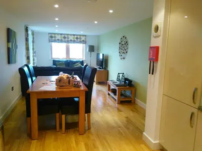 a dining room and living room with a table and chairs at South Fistral Seaview 2-bed Apartment in Newquay