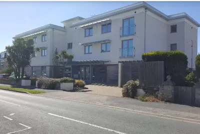 a white building on the side of a street at South Fistral Seaview 2-bed Apartment in Newquay