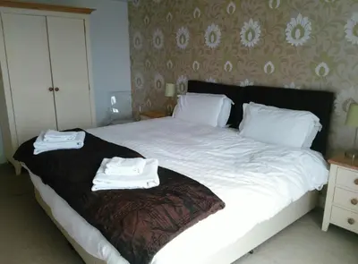 a bedroom with a bed with two towels on it at South Fistral Seaview 2-bed Apartment in Newquay