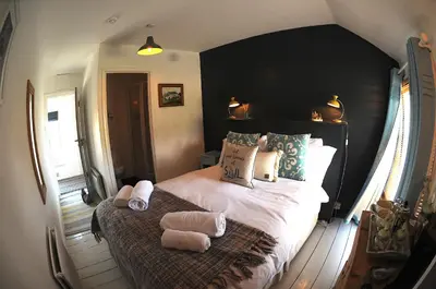 a bedroom with a large bed with two towels on it at Victoria Inn in Penzance