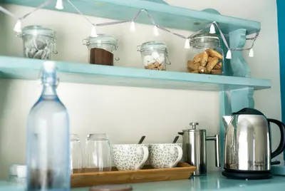 a kitchen counter with jars and a bottle on a shelf at Victoria Inn in Penzance
