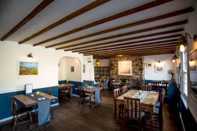 a dining room with wooden tables and chairs at Victoria Inn in Penzance