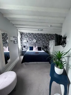 a bedroom with a bed with a blue bedspread at Molesworth Arms in Wadebridge