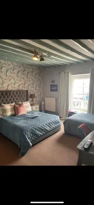 a bedroom with a bed with a blue comforter at Molesworth Arms in Wadebridge