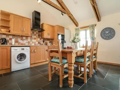 a kitchen with a wooden table and chairs at Ash Cottage in Truro