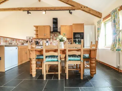 a kitchen with a wooden table and chairs at Ash Cottage in Truro