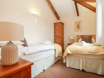 a bedroom with two beds and a table at Ash Cottage in Truro