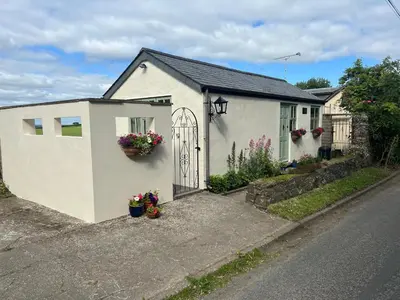 a white house with a gate on the side of a street at Palmers Lodge in Launceston