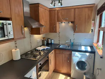 a kitchen with a stove and a washing machine at Palmers Lodge in Launceston